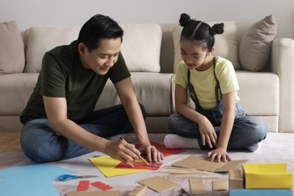 Ayah mendampingi anak belajar sambil memberikan dukungan emosional dan bermain bersama.