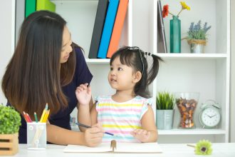 Ibu mendampingi anak mengucapkan kata pertama dan mengenal kosakata