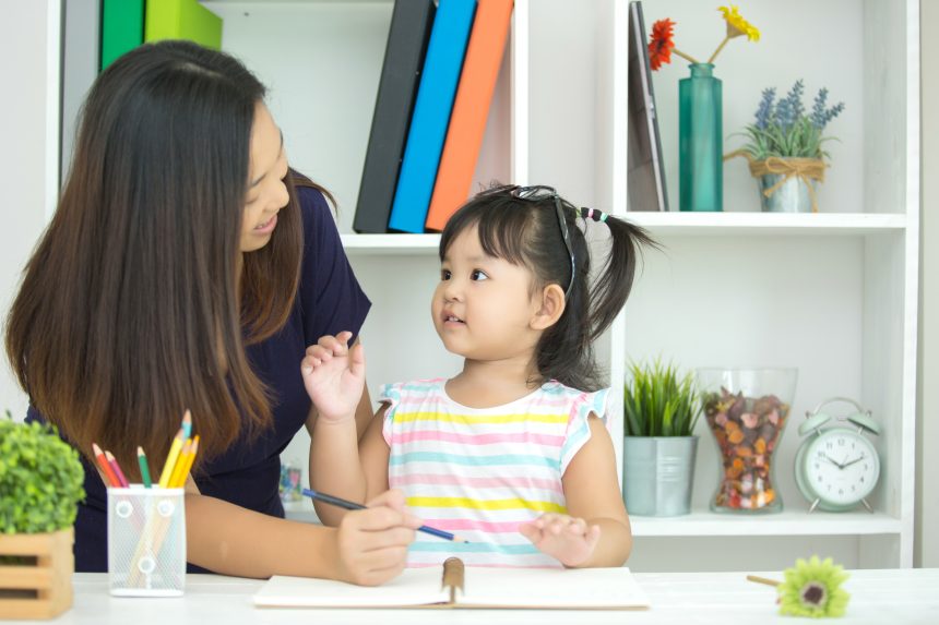 Ibu mendampingi anak mengucapkan kata pertama dan mengenal kosakata