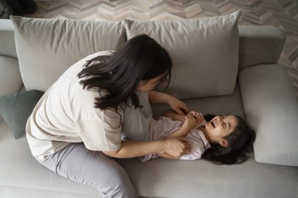 Ibu mendampingi anak mengucapkan kata pertama saat bermain di rumah