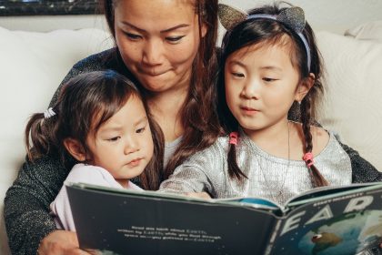 Ibu dan anak membaca buku cerita sambil aktif berbicara