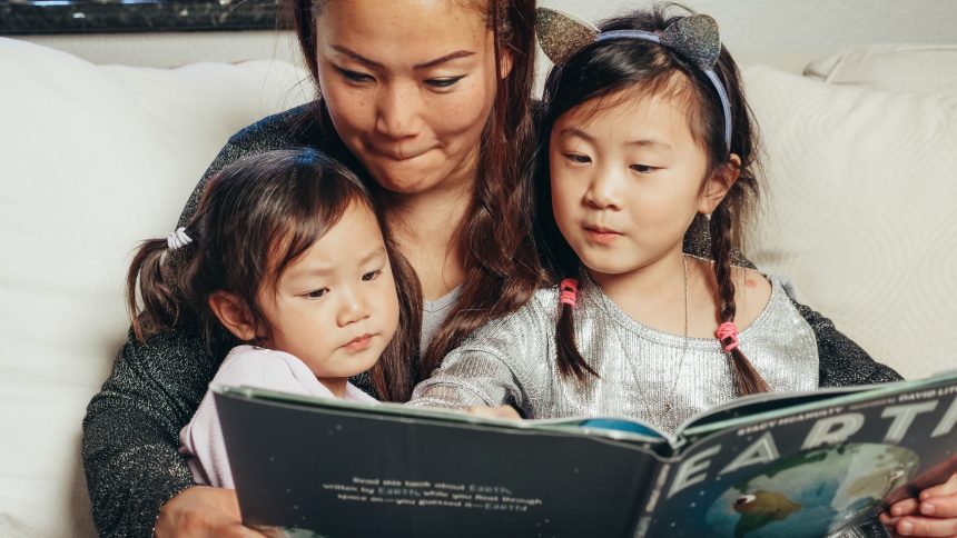 Ibu dan anak membaca buku cerita sambil aktif berbicara