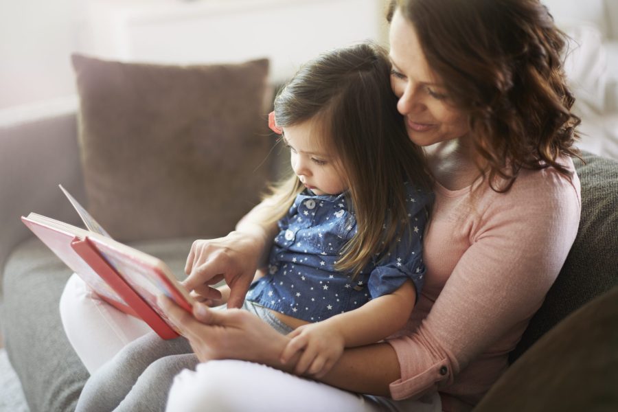 Ibu membaca buku secara interaktif bersama anak dan menunjuk gambar