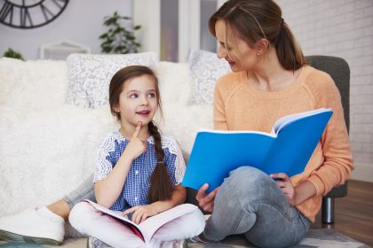 Ibu dan anak membaca buku cerita sambil aktif berbicara