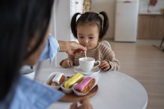 Ibu mendampingi bayi makan sambil berinteraksi untuk mendukung perkembangan otak anak
