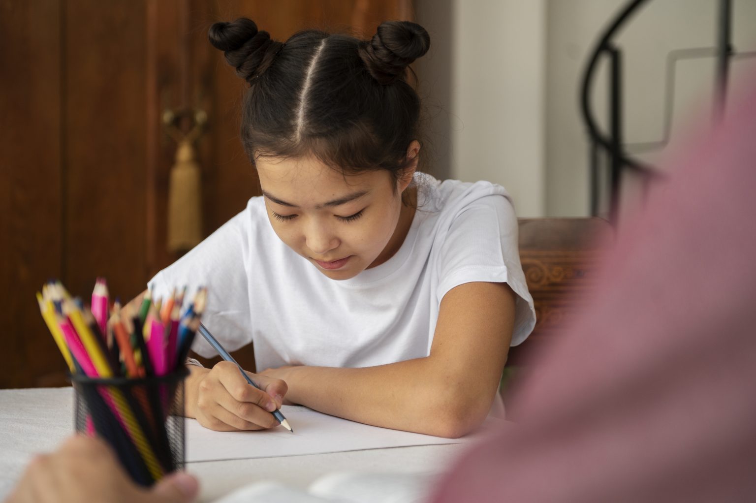 Ibu mendampingi anak belajar sebagai bagian dari latihan kesiapan untuk sekolah anak.
