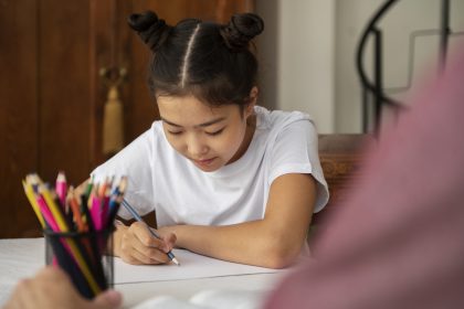 Ibu mendampingi anak belajar sebagai bagian dari latihan kesiapan untuk sekolah anak.
