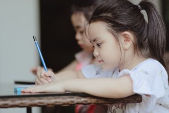 Anak mengikuti aktivitas kelas dengan ekspresi fokus bersama teman.