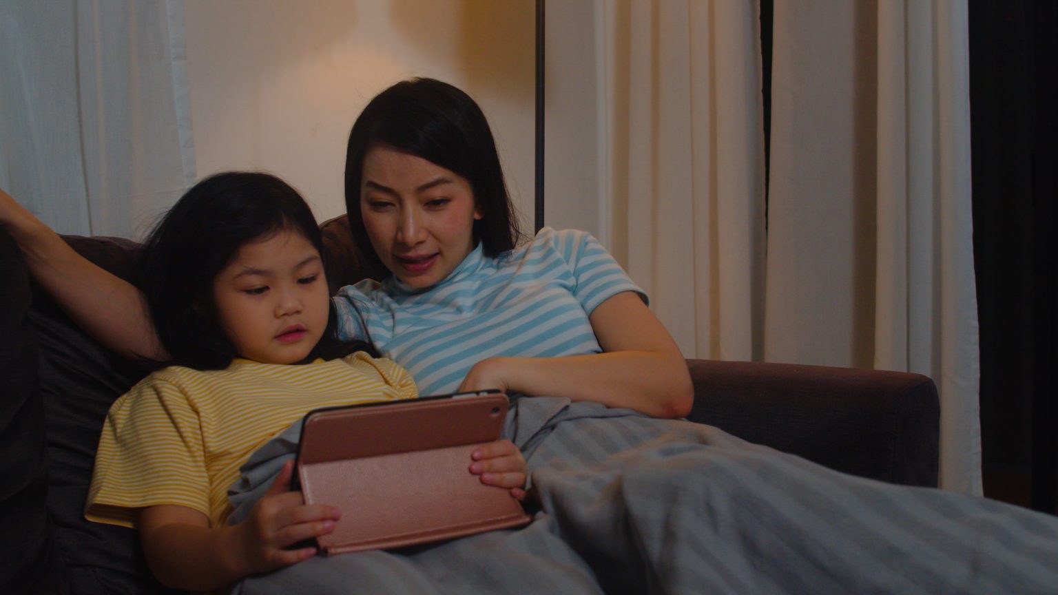 Ibu dan anak melakukan rutinitas sebelum tidur sambil membaca dan mengobrol untuk melatih bicara