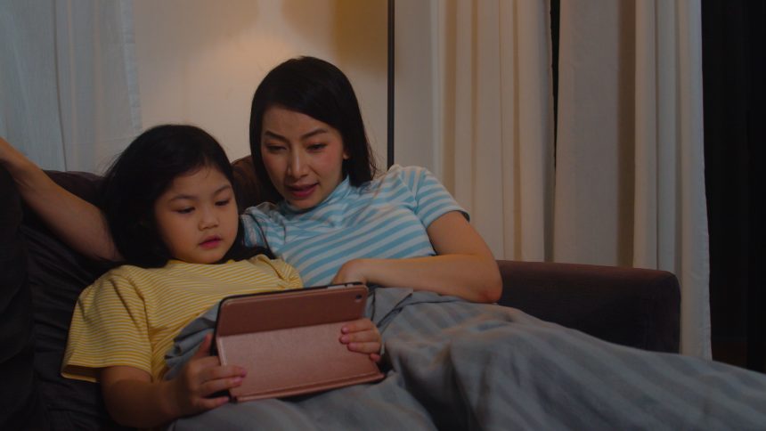 Ibu dan anak melakukan rutinitas sebelum tidur sambil membaca dan mengobrol untuk melatih bicara