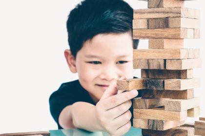 Anak mencoba menyusun balok dan mencari solusi saat bermain untuk melatih problem solving.