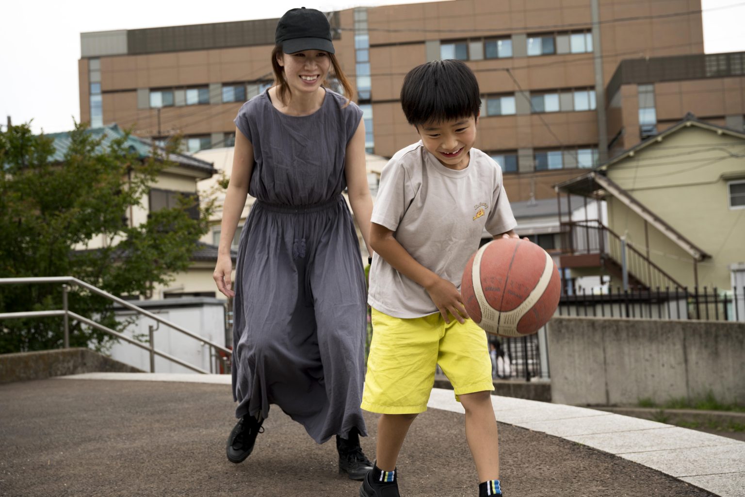 Ibu mendampingi anak bermain basket untuk memahami hubungan sebab-akibat saat bermain.