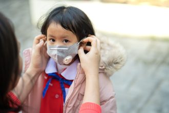 Anak menggunakan masker saat abu vulkanik