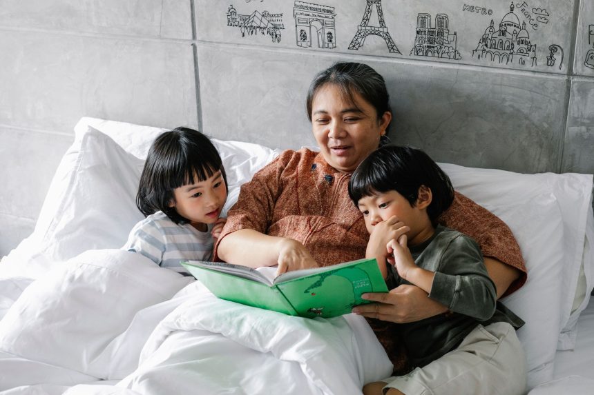 Ibu membaca buku sebelum tidur untuk mendukung bahasa anak.