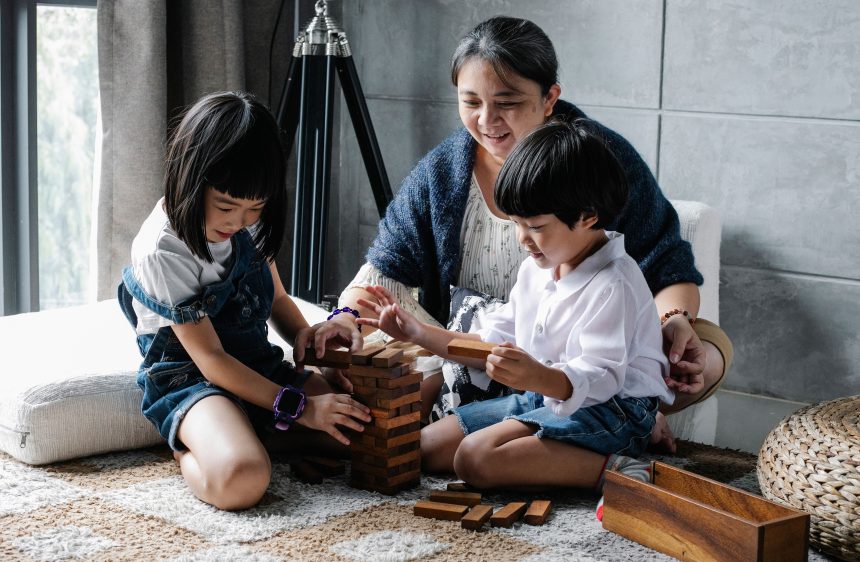 Orang tua mendampingi anak mengakhiri screen time dan beralih ke permainan balok di rumah.