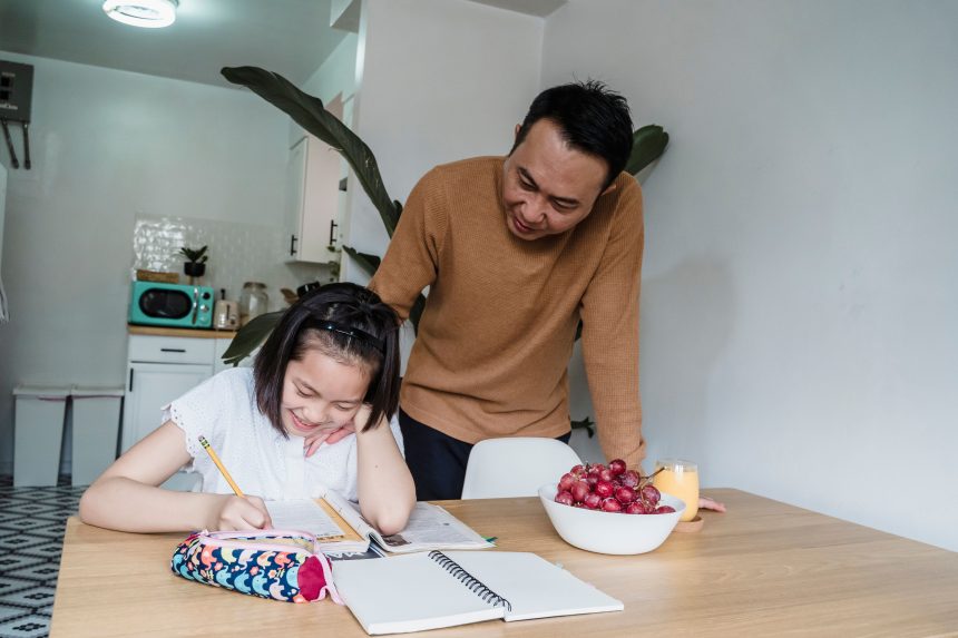 Orang tua mendampingi anak menyelesaikan satu tugas belajar sederhana di rumah dengan suasana tenang.