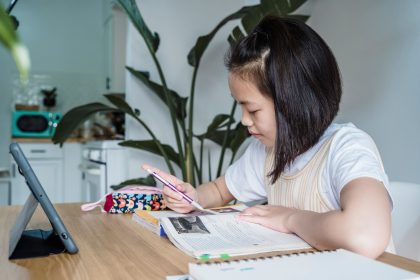 Anak beralih dari menggunakan tablet ke membaca buku dengan pendampingan orang tua untuk membantu transisi perhatian.