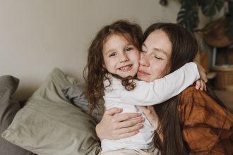 Ibu mendampingi anak mengucapkan kata pertama yang bermakna.