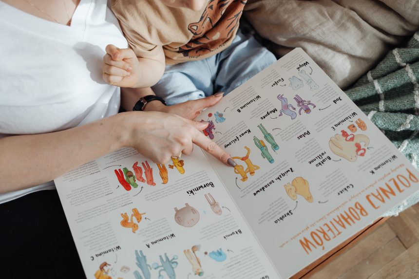 Ibu dan anak membaca buku interaktif sambil menunjuk gambar hewan