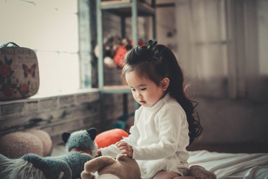 Anak mengamati bayangan boneka dengan senter saat bermain eksperimen sederhana