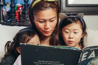 Ibu mengamati perkembangan bicara anak saat membaca buku bersama.