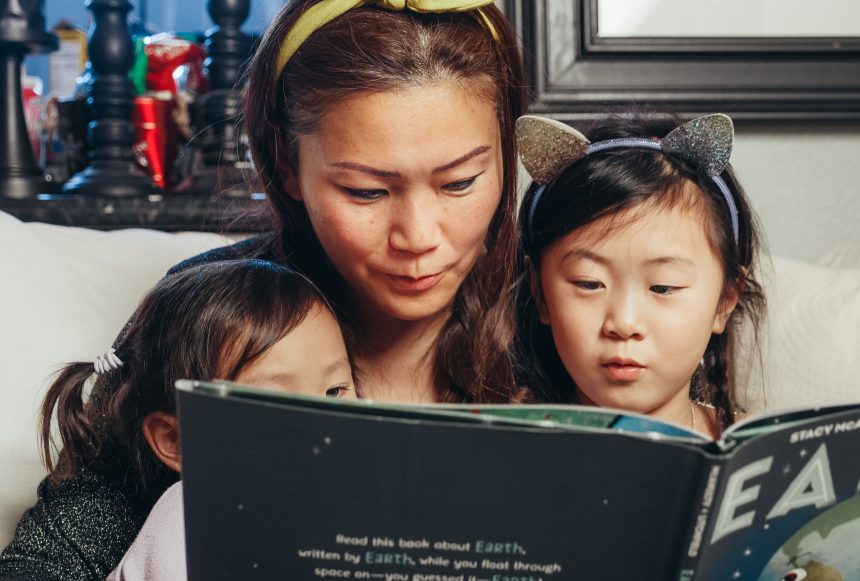 Ibu mengamati perkembangan bicara anak saat membaca buku bersama.