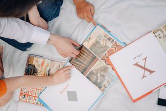 Ibu dan anak membaca buku interaktif untuk melatih bahasa