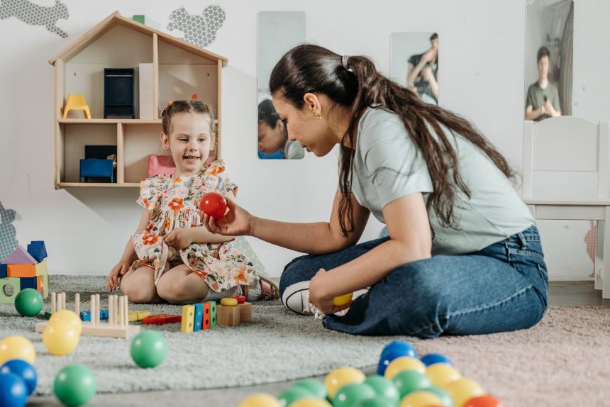 Anak dan ibu mencoba lintasan bola dari kardus untuk belajar sebab-akibat