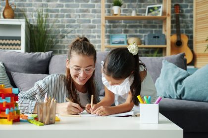 Ibu mendampingi anak menyiapkan perlengkapan sekolah sambil berbincang di rumah
