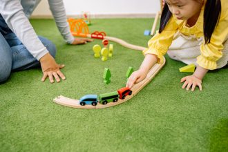Anak prasekolah bermain aktivitas motorik halus bersama ibu di rumah